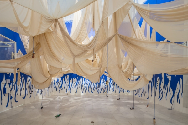 artwork by Amanda Coogan featuring fabric draped across the Atrium gallery with vintage shoes hanging from it 
