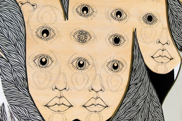 Detail of the artwork Yūrei (Ghosts) by Hiromi Moneyhun featuring three connected wooden faces with nine eyes