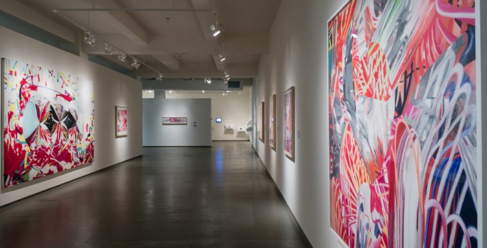 a hallway of artwork in the Time Zones exhibition