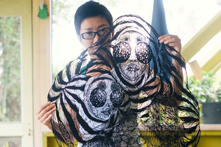 Hiromi Moneyhun holding a piece of her artwork