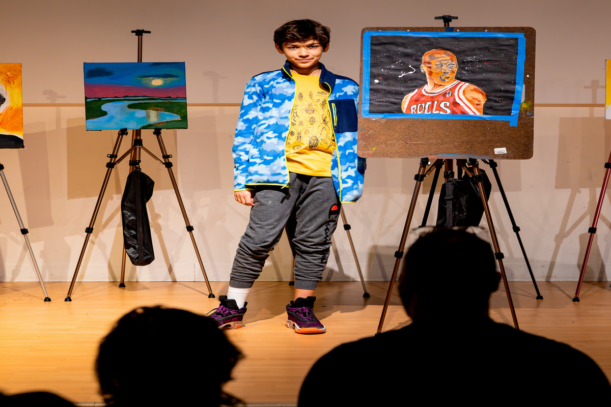 student on stage showcasing artwork