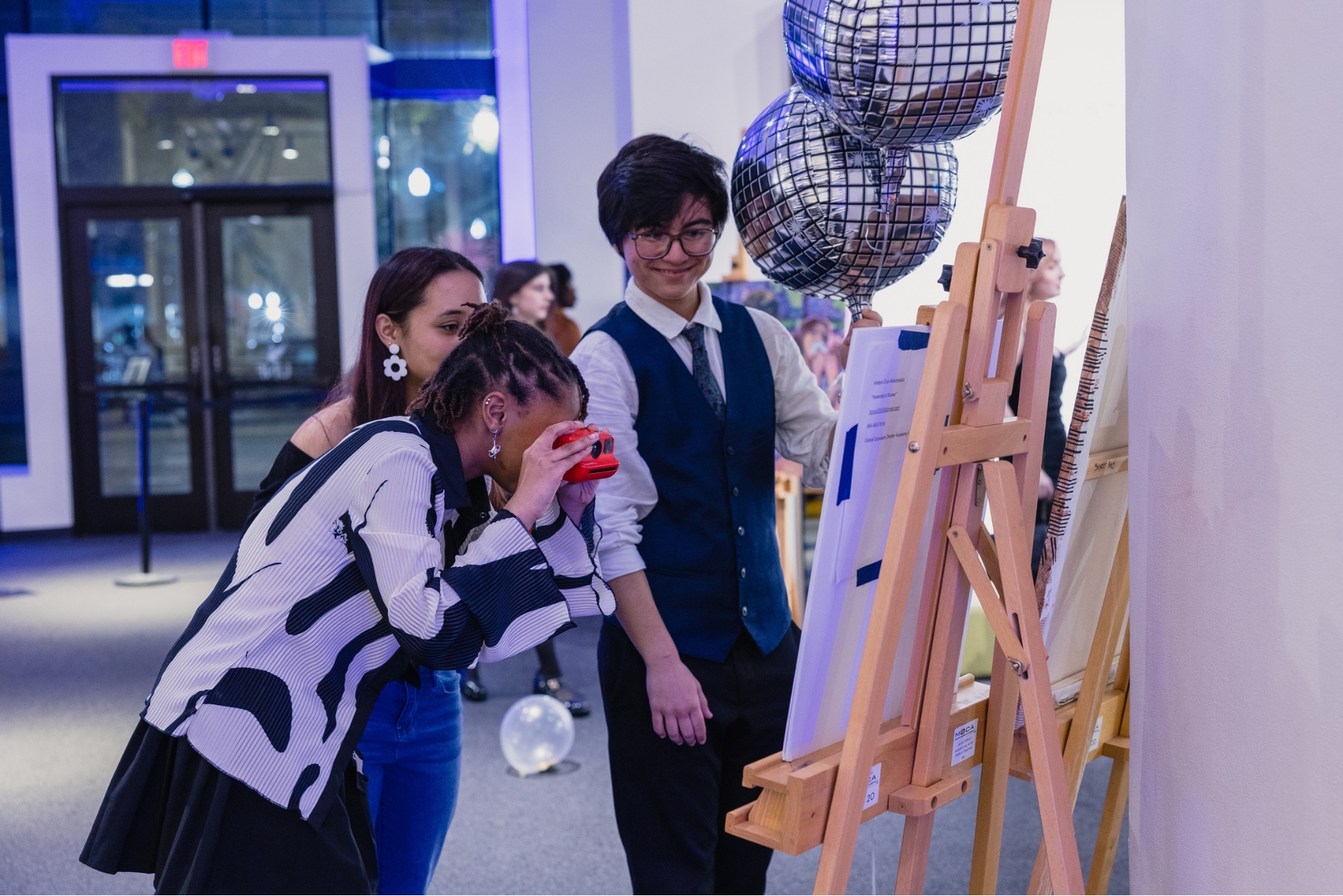 Teens taking a photo of art during an event at MOCA
