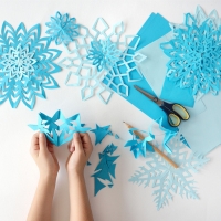 a kid cutting out paper snowflakes