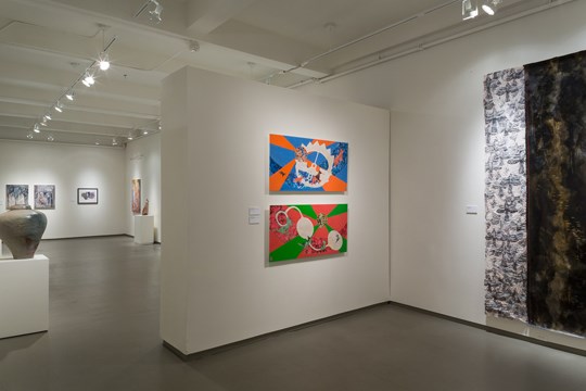 long view of museum with two colorful paintings in the forefront