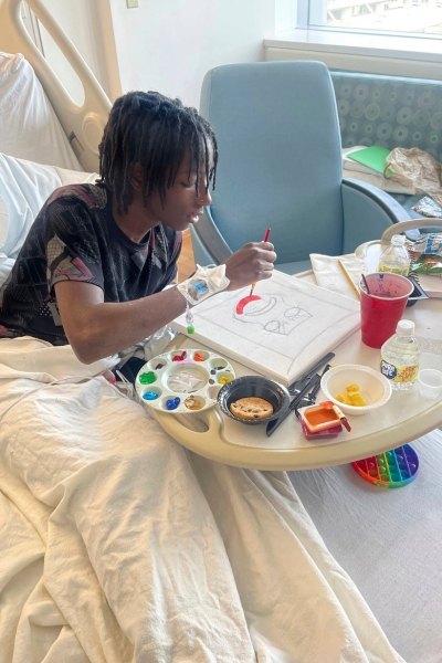 a teen works on a painting while enjoying snacks