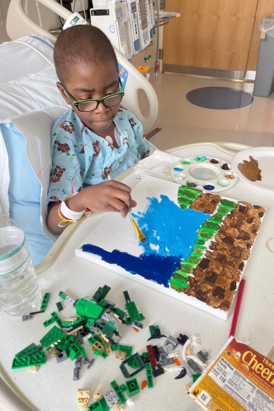 a child works on a painting that is inspired by legos 