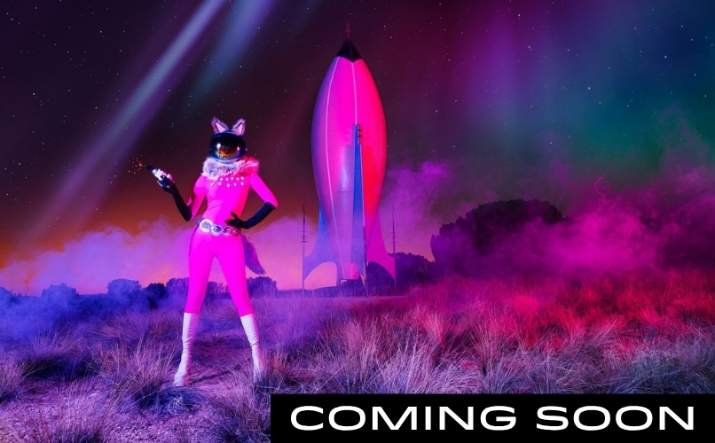 Photograph by Cara Romero of a figure in a pink spacesuit before a rocket in a desert beneath a starry sky. Text reads ‘Coming Soon.’ click for more information about this exhibition