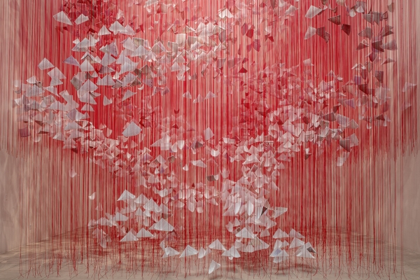 artwork by Chiharu Shiota featuring red string hanging with love letters attached 