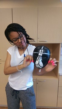 artist with her black mask with white prayer hands