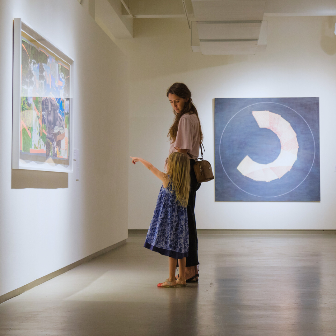 a mother and daughter look at art in the galleries at MOCA