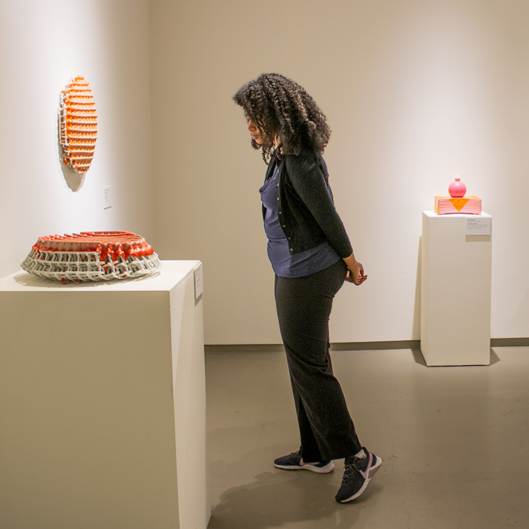 a guest looks at ceramic art in MOCA 