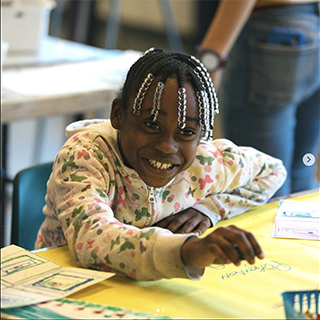 child smiling at a the Kids Art Lab