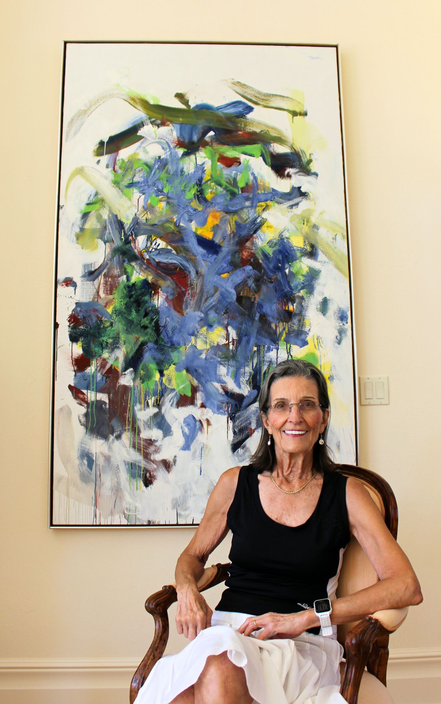 Maria Cox sitting in front of an abstract painting