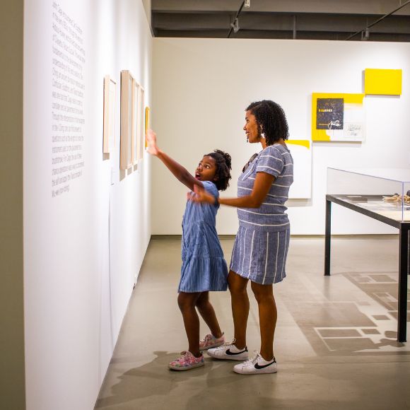 mother and daughter looking at art in a gallery